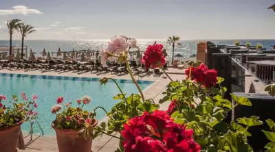 Guadalmina Hotel swimming pool with red flowers in the foreground