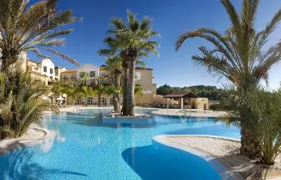 Hotel La Sella swimming pool with palm trees.